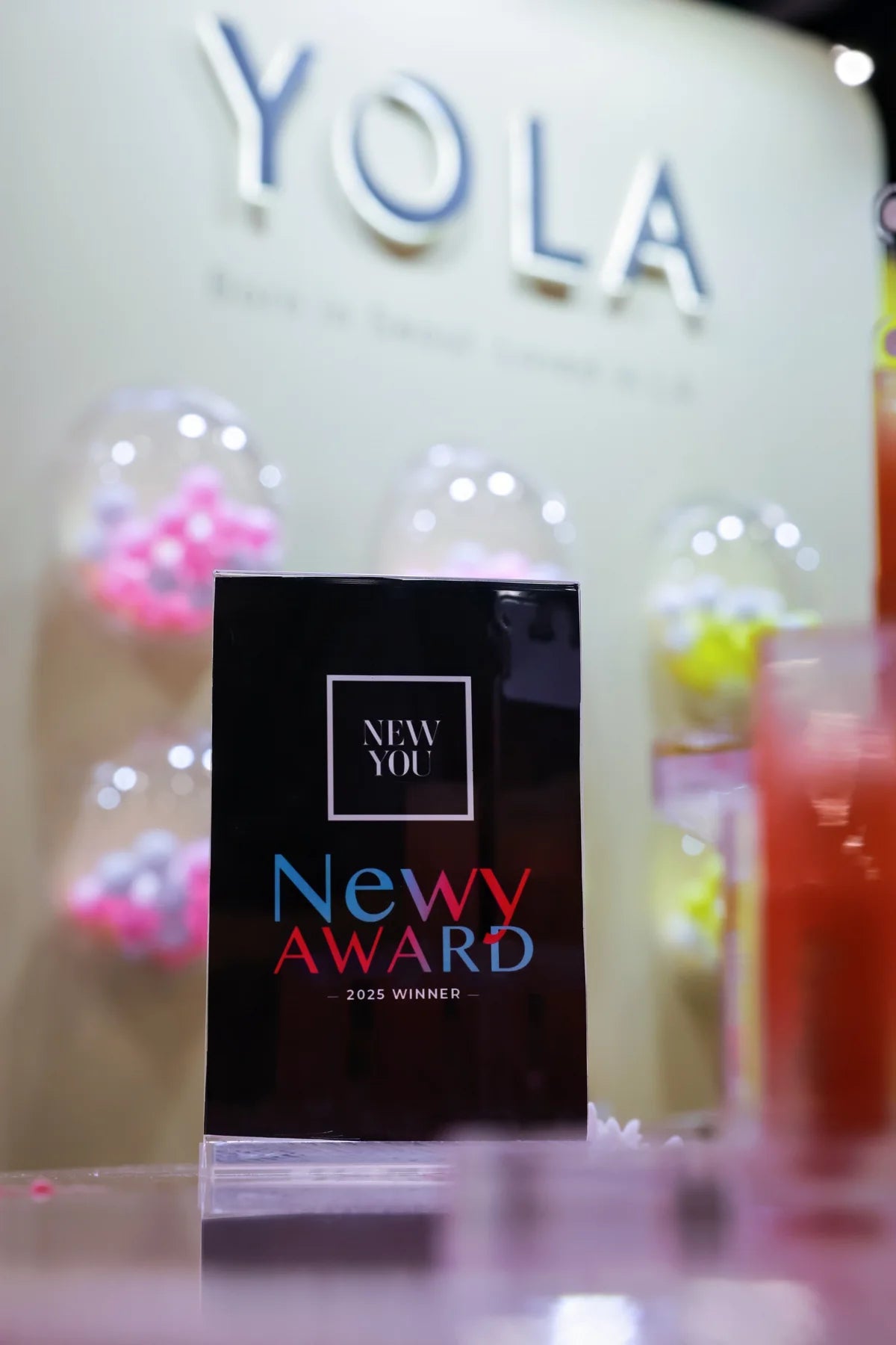 A NEW YOU Newy Award trophy, photographed against the Yola display.