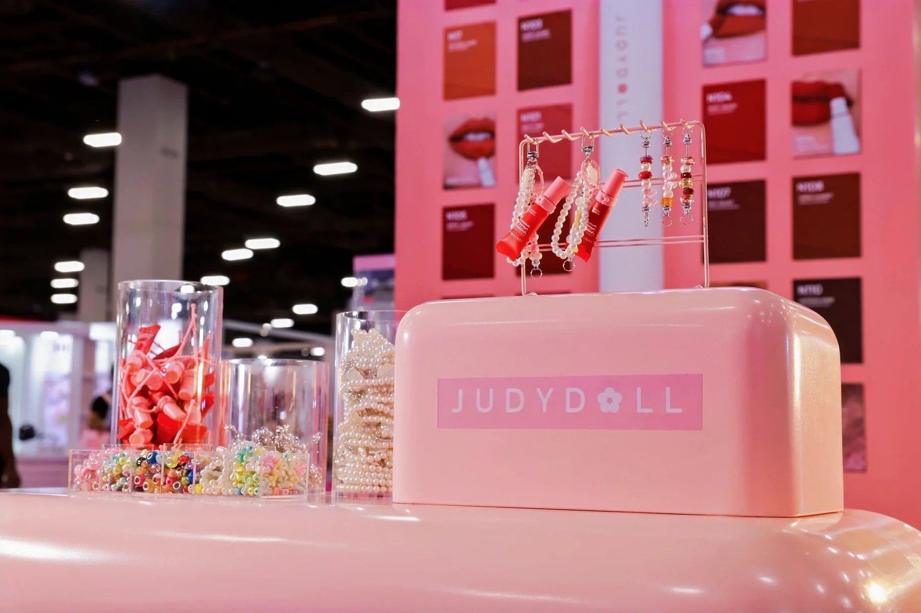 A pink JUDYDOLL display uses bold branding and small decorative details to frame the products.