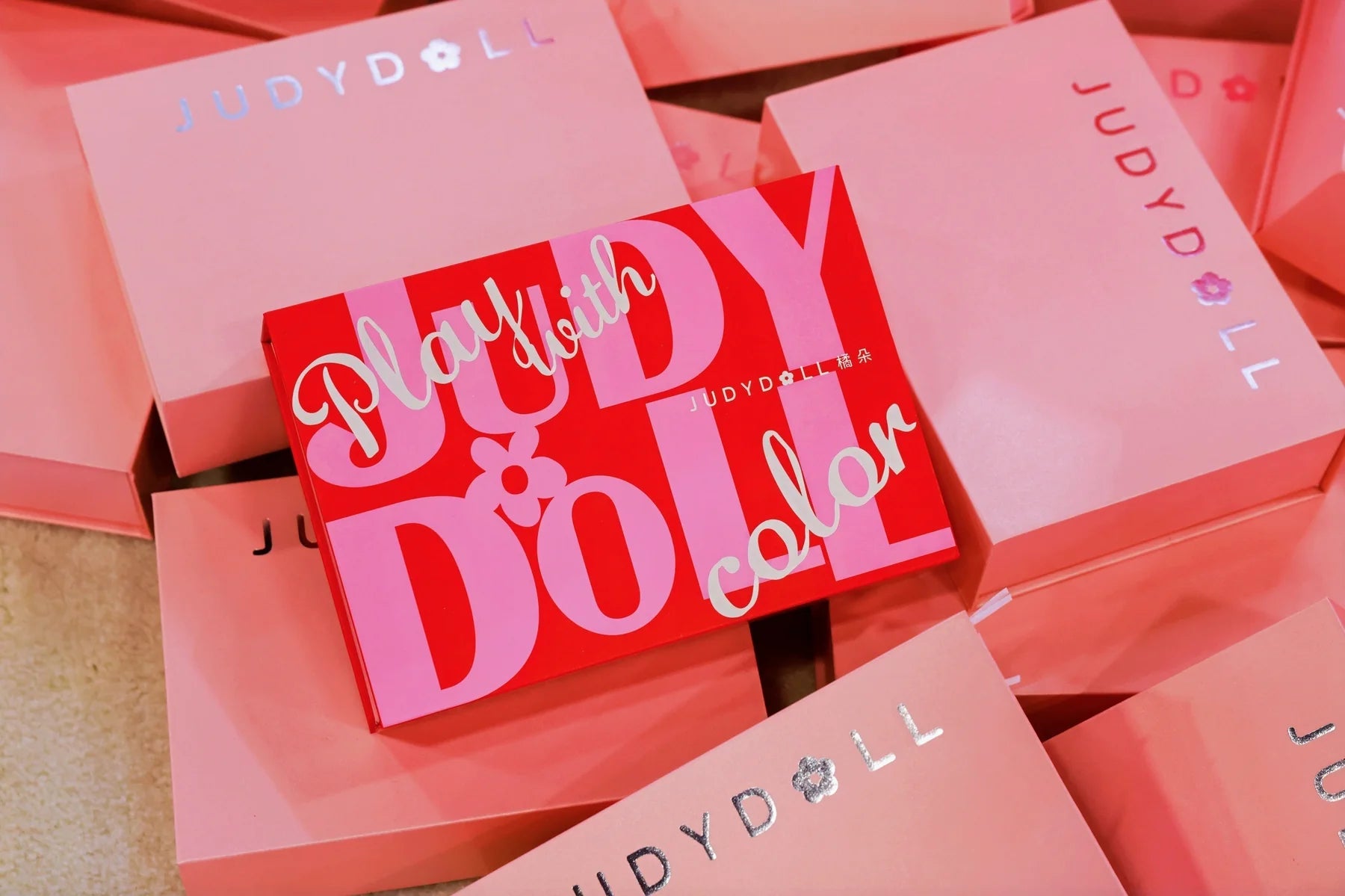 JUDYDOLL's pink bags and printed materials carry the booth's identity beyond the display.