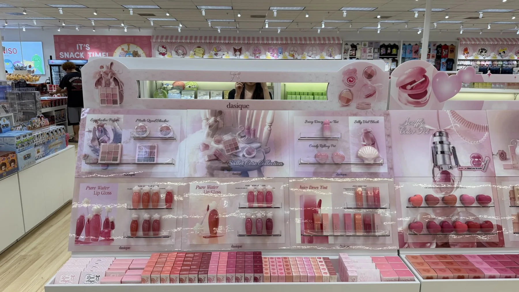 A softly lit beauty fixture organizes palettes, lip products and testers into a browsable display.