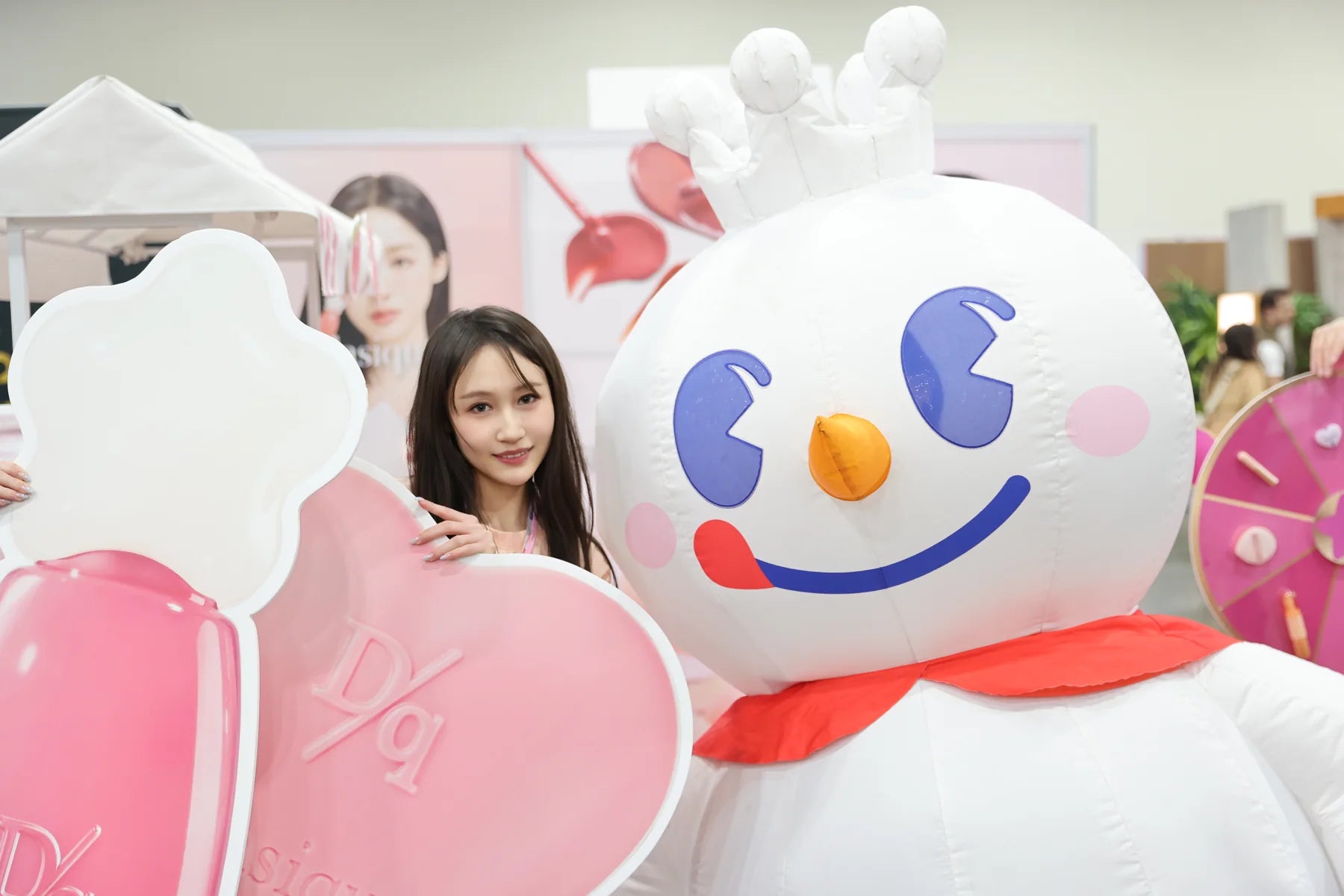 A playful mascot photo closes the day with the same pink palette as the booth.